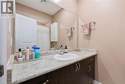 Spacious vanity with an integrated sink, stone-finish countertop, and dark wood cabinetry - 