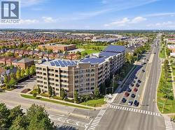 Multi-story residential building featuring a stone and stucco exterior, multiple solar panel arrays, and manicured landscaping - 