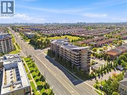 Aerial perspective featuring a multi-story building with solar panels, surrounded by a developed neighborhood, expansive green spaces, and an urban skyline in the distance - 