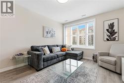 Light wood-finish flooring with white baseboards, bright white window trim, and white plantation shutters - 