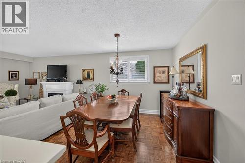 Hardwood parquet flooring, neutral wall tones, white window shutters, and a chandelier lighting fixture - 1434 Dewbourne Crescent, Burlington, ON 