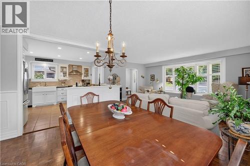 Hardwood-finish flooring, recessed lighting, and a chandelier illuminate the dining space - 1434 Dewbourne Crescent, Burlington, ON 