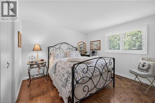 Wood-finish parquet flooring, white walls, and a window with white louvered blinds - 1434 Dewbourne Crescent, Burlington, ON 