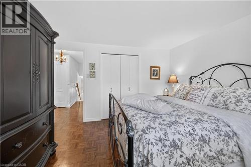 White walls, wood-finish flooring, and a built-in closet with bi-fold doors - 1434 Dewbourne Crescent, Burlington, ON 