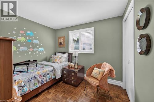 Parquet wood-finish flooring, built-in closet with white doors, window with white blinds, neutral wall paint - 1434 Dewbourne Crescent, Burlington, ON 