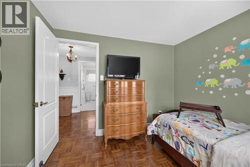 Hardwood parquet flooring, neutral wall color, white paneled door, and brass hardware - 1434 Dewbourne Crescent, Burlington, ON 