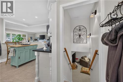 Kitchen with a light-toned tile floor, a teal island with a wood countertop, and a black countertop on a white cabinet - 1434 Dewbourne Crescent, Burlington, ON 