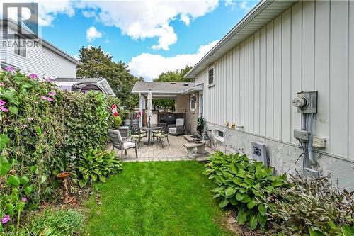 Manicured lawn with a paver patio and covered outdoor structure - 1434 Dewbourne Crescent, Burlington, ON 