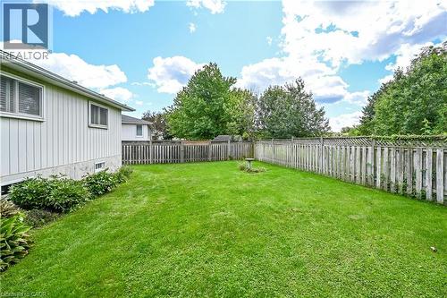 Expansive grassy yard with perimeter fencing, mature trees, and established shrubbery - 1434 Dewbourne Crescent, Burlington, ON 