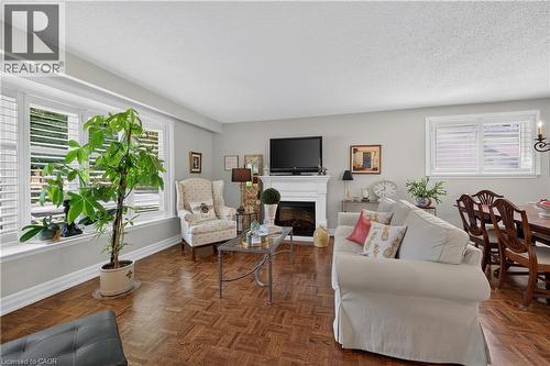 Parquet wood-finish flooring throughout, white fireplace mantel, and white interior window shutters - 1434 Dewbourne Crescent, Burlington, ON 