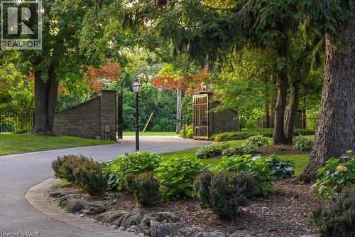 Stone entry pillars with integrated lighting and wrought iron gates - 4038 Lakeshore Road, Burlington, ON 