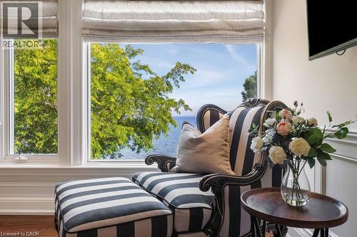 Large windows with integrated Roman shades, white trim, and wood-finish flooring - 4038 Lakeshore Road, Burlington, ON 