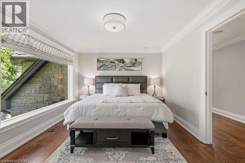 Expansive window providing ample natural light, crown molding detailing, recessed ceiling light fixture, wood-finish flooring, and a neutral wall palette - 4038 Lakeshore Road, Burlington, ON 