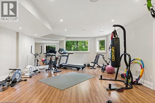 Spacious lower-level room featuring wood-finish flooring, recessed lighting, and multiple windows - 4038 Lakeshore Road, Burlington, ON 