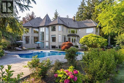 Stone exterior with multiple dormers and a turretted roofline - 4038 Lakeshore Road, Burlington, ON 