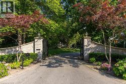 Stone-clad entry wall with wrought iron gates and integrated lighting - 