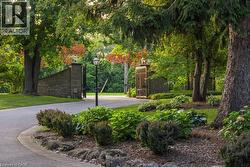 Stone entry pillars with integrated lighting and wrought iron gates - 