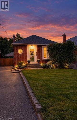 Brick exterior with a dark shingle roof and a prominent chimney - 107 Norwood Road, Hamilton, ON 