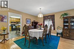 Hardwood flooring, overhead lighting fixture, window with blinds, and built-in display cabinet - 
