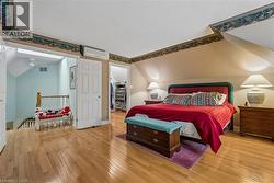 Hardwood flooring, sloped ceilings, recessed lighting, and a built-in wardrobe - 