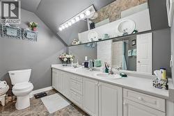 Dual vanity with integrated sinks, extensive countertop space, white cabinetry, and a full-width mirror - 