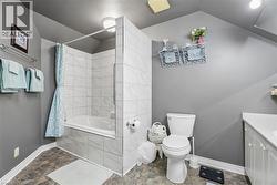 Bathtub with tile surround, white vanity, and gray wall paint - 