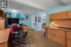 Built-in wood-finish cabinetry, neutral-toned patterned carpet, recessed ceiling lighting, and a white interior door - 