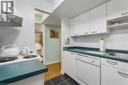 Functional kitchen with white cabinetry, a built-in dishwasher, and a stainless steel sink - 