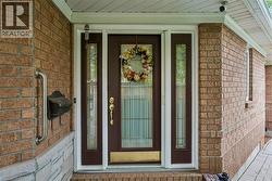 Brick exterior featuring a brown door with glass sidelights, a brass kickplate, and a brass door handle - 