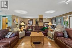 Expansive living area with wood-finish flooring, recessed lighting, and direct access to an enclosed porch - 