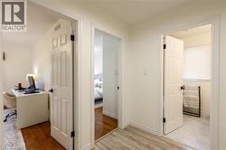 Bright hallway with light wood-finish flooring and white paneled doors - 