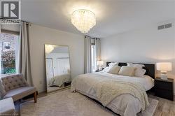 Wood-finish flooring, a modern chandelier, and a built-in closet with bi-fold doors - 