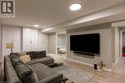 Built-in storage cabinetry, recessed lighting, wood-finish flooring, and a wall-mounted television - 