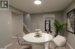 Recessed ceiling light, wood-finish flooring, staircase with white railing, light-toned wall paint, doorway leading to another area - 