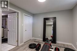 Wood-finish flooring, light gray wall paint, and a built-in closet with bifold doors - 