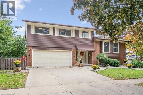 Brick and horizontal siding exterior with a two-car garage, concrete driveway, and mature landscaping - 21 Colebrook Court, Kitchener, ON 