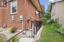 Brick exterior with a side entrance and concrete steps leading to a lower level - 