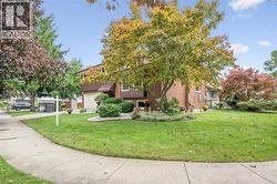 Brick exterior with wood-paneled accents, attached two-car garage, and established landscaping - 