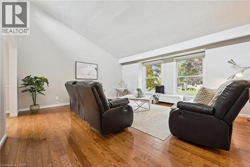Vaulted ceiling with a neutral paint palette, wood-finish flooring, and large windows - 21 Colebrook Court, Kitchener, ON 