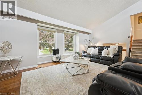 Hardwood-finish flooring, a window bench, and a carpeted staircase - 21 Colebrook Court, Kitchener, ON 
