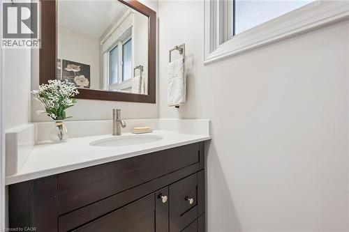 Dark wood-finish vanity with paneling, white countertop, undermount sink, and brushed nickel faucet - 21 Colebrook Court, Kitchener, ON 