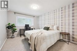 Wall-to-wall carpeting, window with a black curtain rod, recessed ceiling light fixture, and a striped accent wall - 