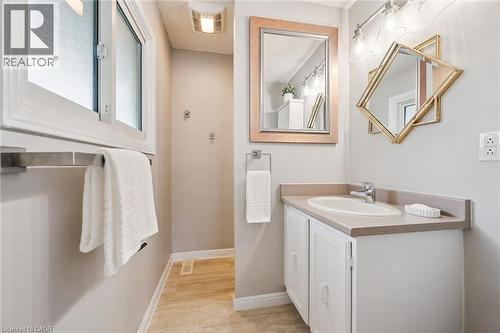 White vanity with an integrated sink and countertop, track lighting fixture, and frosted window - 21 Colebrook Court, Kitchener, ON 