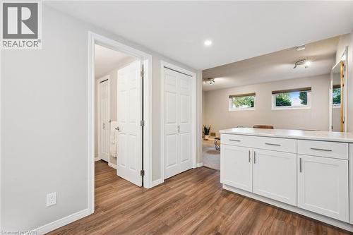 Wood-finish flooring, white cabinetry with a light-toned countertop, recessed lighting, and track lighting fixtures - 21 Colebrook Court, Kitchener, ON 