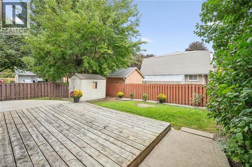 Expansive wood deck with a privacy fence, concrete patio, and a storage shed - 21 Colebrook Court, Kitchener, ON 