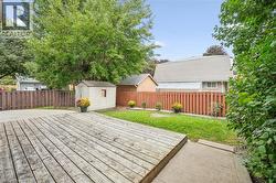 Expansive wood deck with a privacy fence, concrete patio, and a storage shed - 