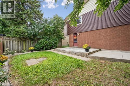 Private backyard featuring a wood deck, concrete patio, and mature perimeter trees - 21 Colebrook Court, Kitchener, ON 