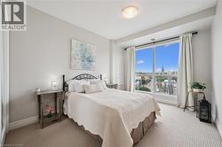 Wall-to-wall carpeting, expansive window, neutral wall tones, ceiling-mounted light fixture, and white window treatments - 