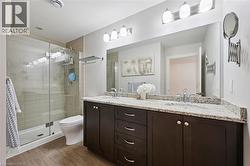 Dual-sink vanity with a light-colored stone countertop and dark wood-finish cabinetry - 