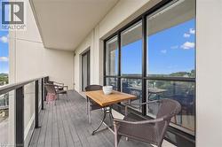 Private balcony with composite decking, glass panel railings, and floor-to-ceiling windows - 